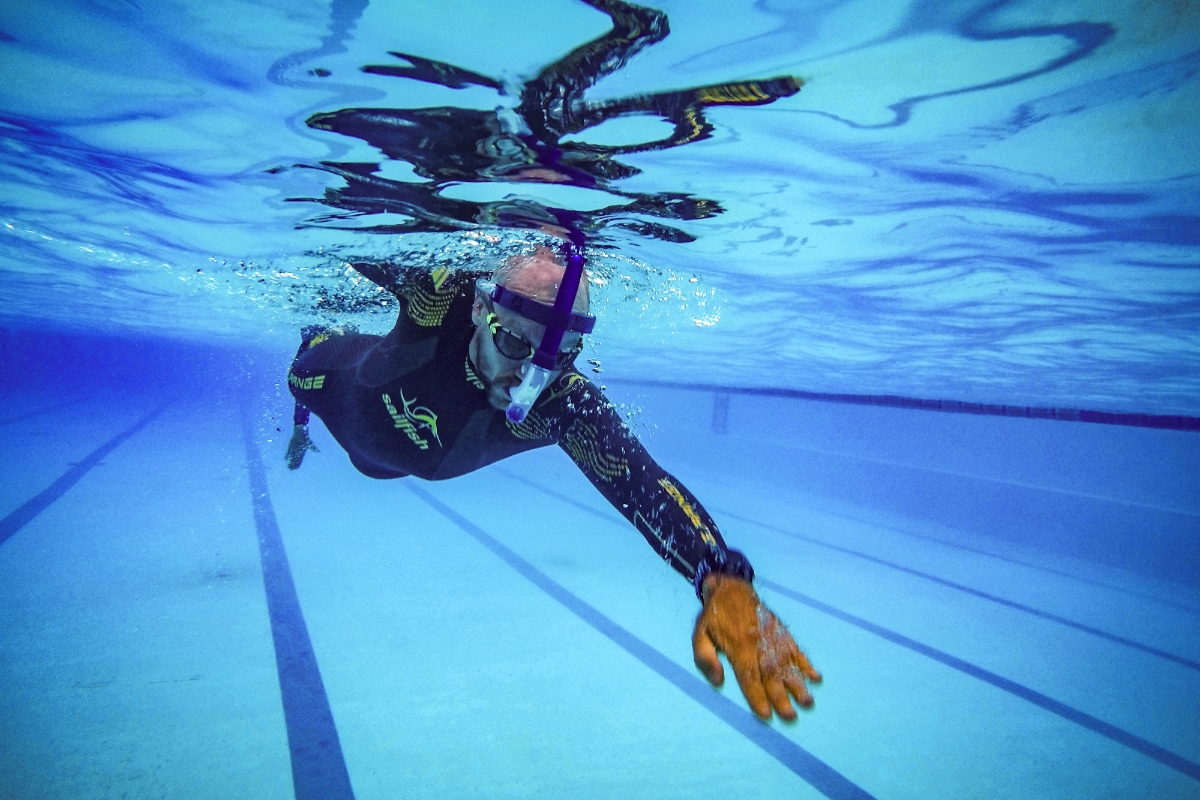 Person swimming front crawl in outdoor swimming pool