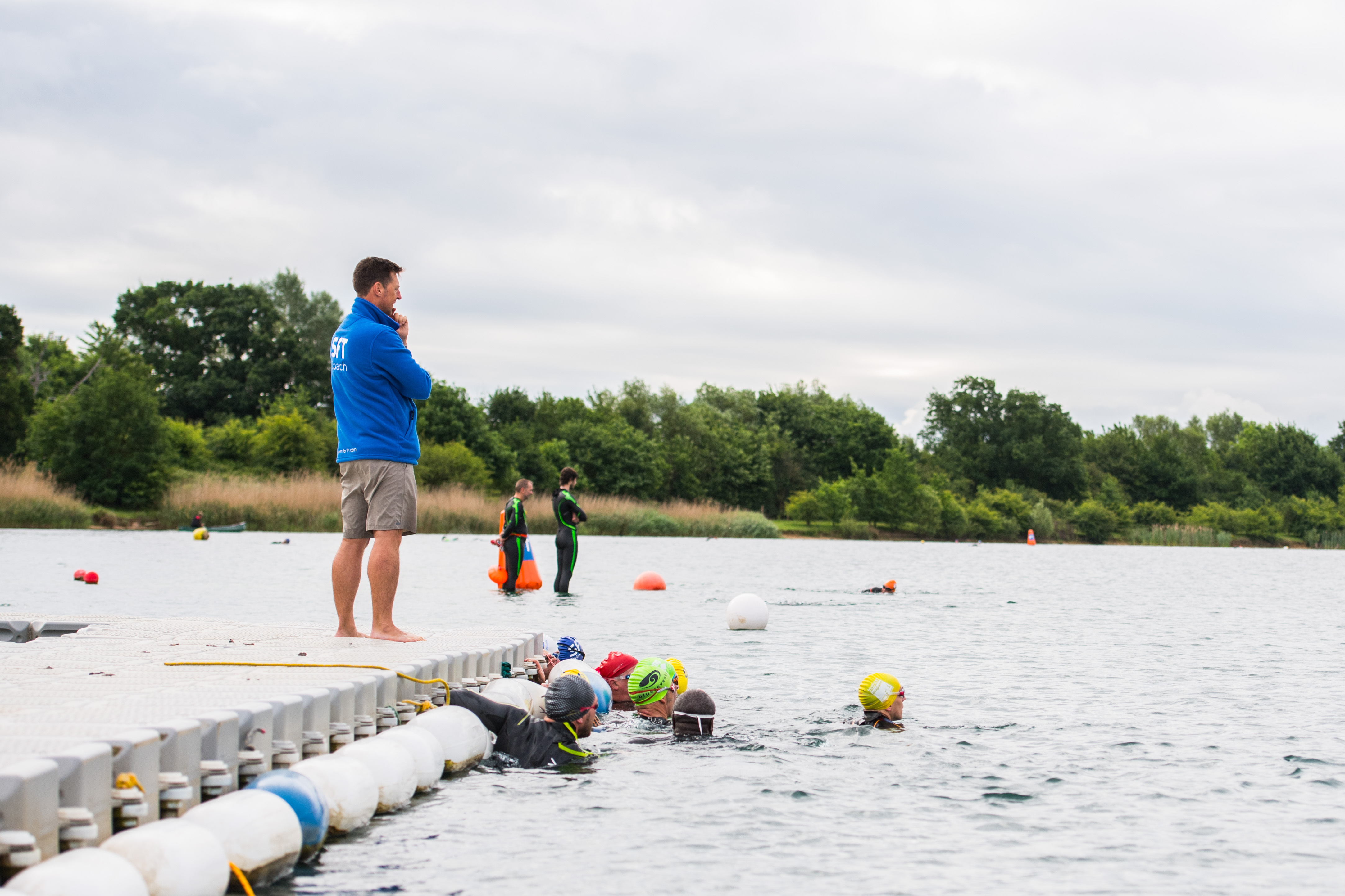 SFT coach watching swimmers enter the lake